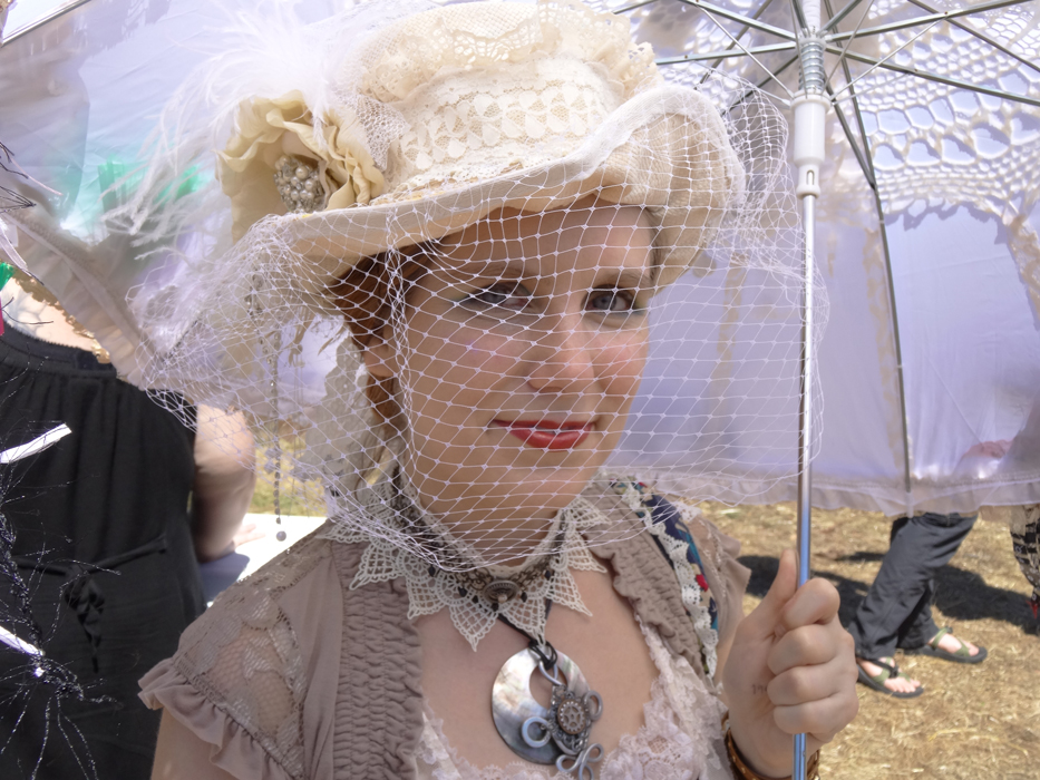 steampunk author photo with handcrafted top hat, parasol, necklace and lacy things.